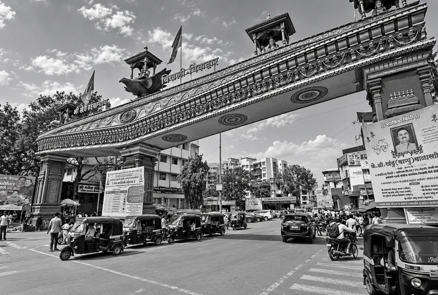The decorated entrance arch at Chikhali spanning the road, with shops along both sides.